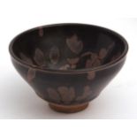 Japanese red clay tea bowl with a thick black Tenmoku iron glaze applied using a splashed wax resist