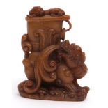 Finely carved Chinese soapstone of dark amber colour, depicting a Buddhist lion dog with a ritual