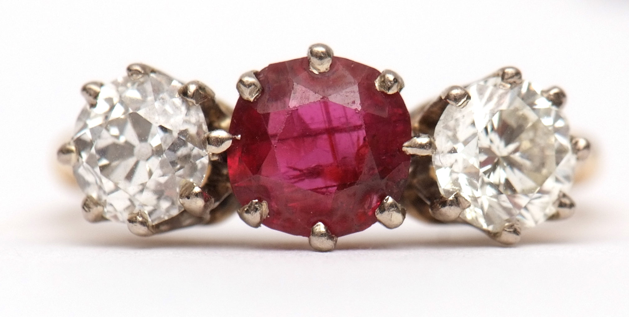 Precious metal ruby and diamond three-stone ring, the circular cut ruby 0.73ct (est) between two old