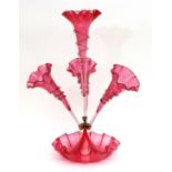 Victorian cranberry glass four-flute epergne, each flute with a crimped rim and with clear glass