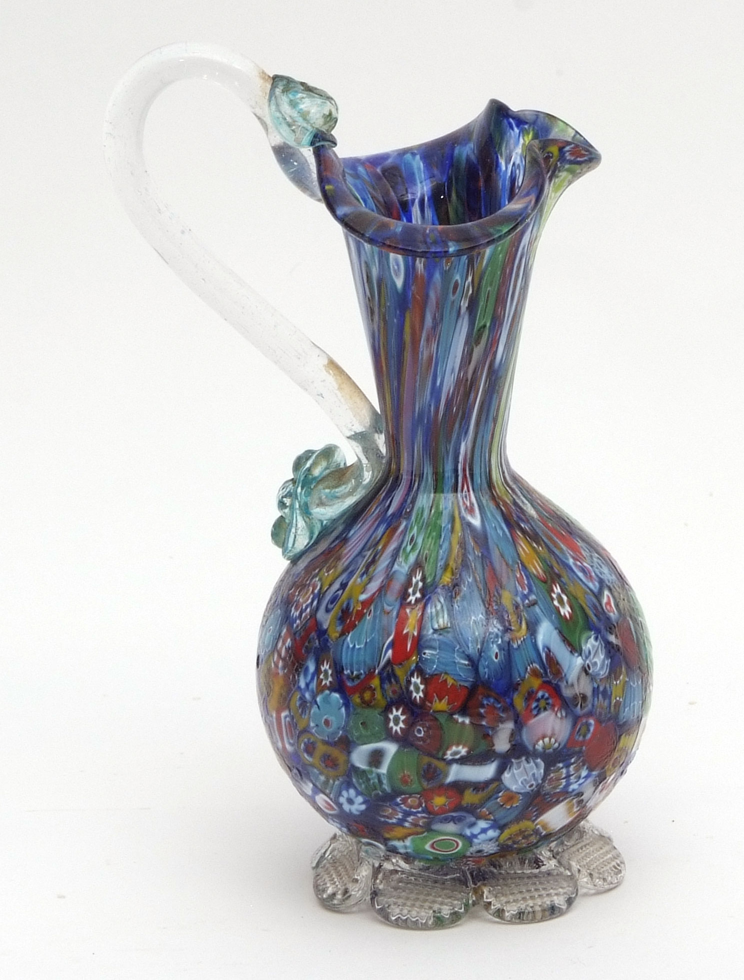 Millefiori small ewer with trefoil neck, clear glass handle and the body typically decorated with