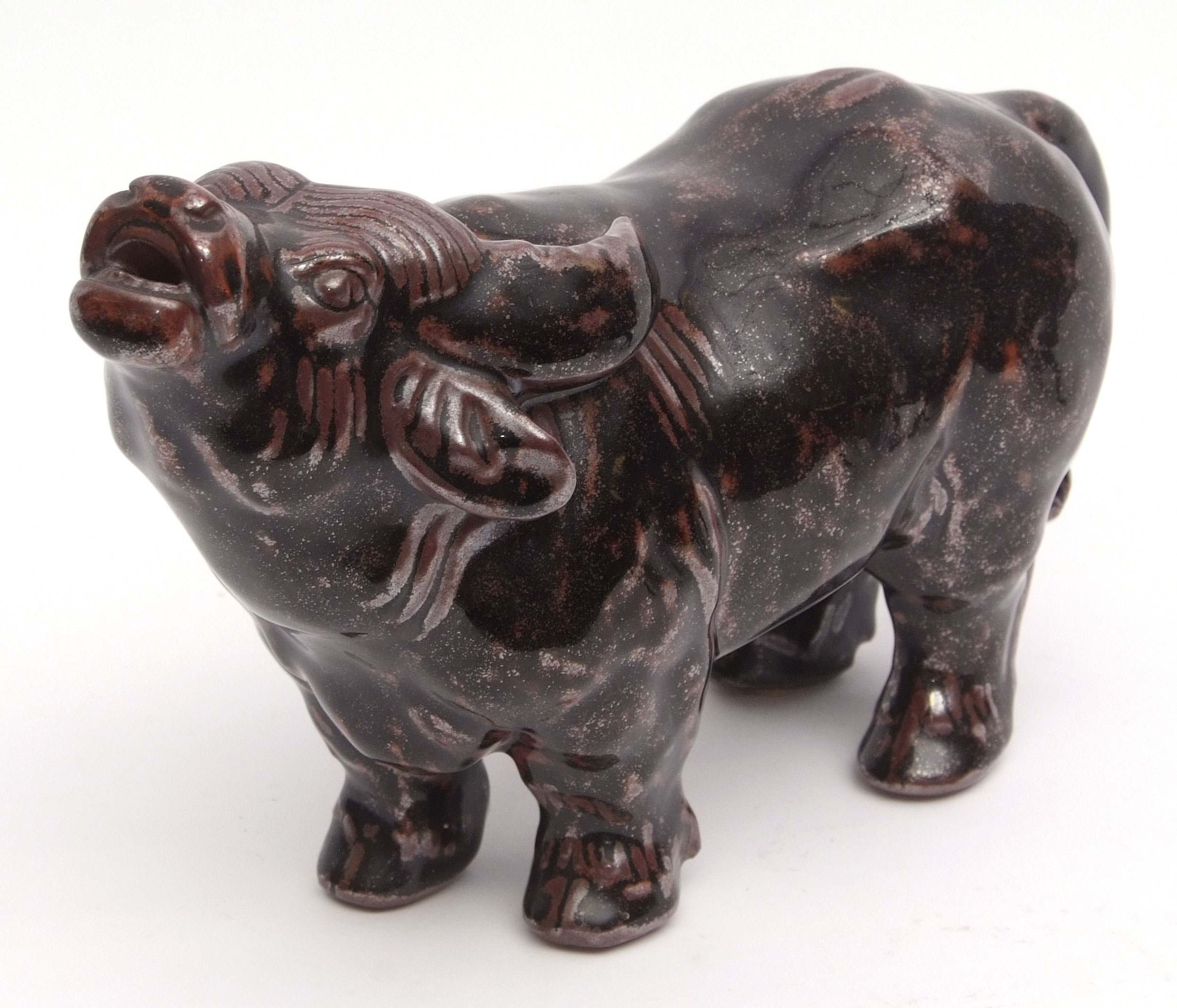 Oriental ceramic model of a water buffalo with heavy mottled black and maroon glaze, 20cm high