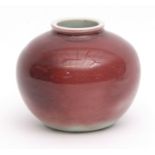 Small Chinese porcelain vase or brush washer with mottled dark red glaze fading towards the foot,