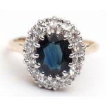 Modern sapphire and diamond cluster ring, the oval faceted sapphire (8 x 6mm) within a diamond