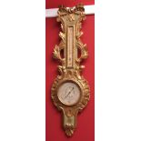 19th century French gilt wood and painted barometer, the shaped case with carved foliate and