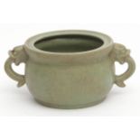 Chinese porcelain censer with applied animal mask handles, covered in a pale green crackle glaze,