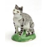 Very rare Lowestoft model of a cat, circa 1780, seated on a green base, the animal with a na ve