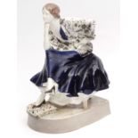 Large Goldscheider model of a young lady in flounced blue skirt and pensive pose, seated on a