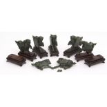 Set of seven Chinese dark green hardstone (probably jade) prancing horses with fitted hardwood