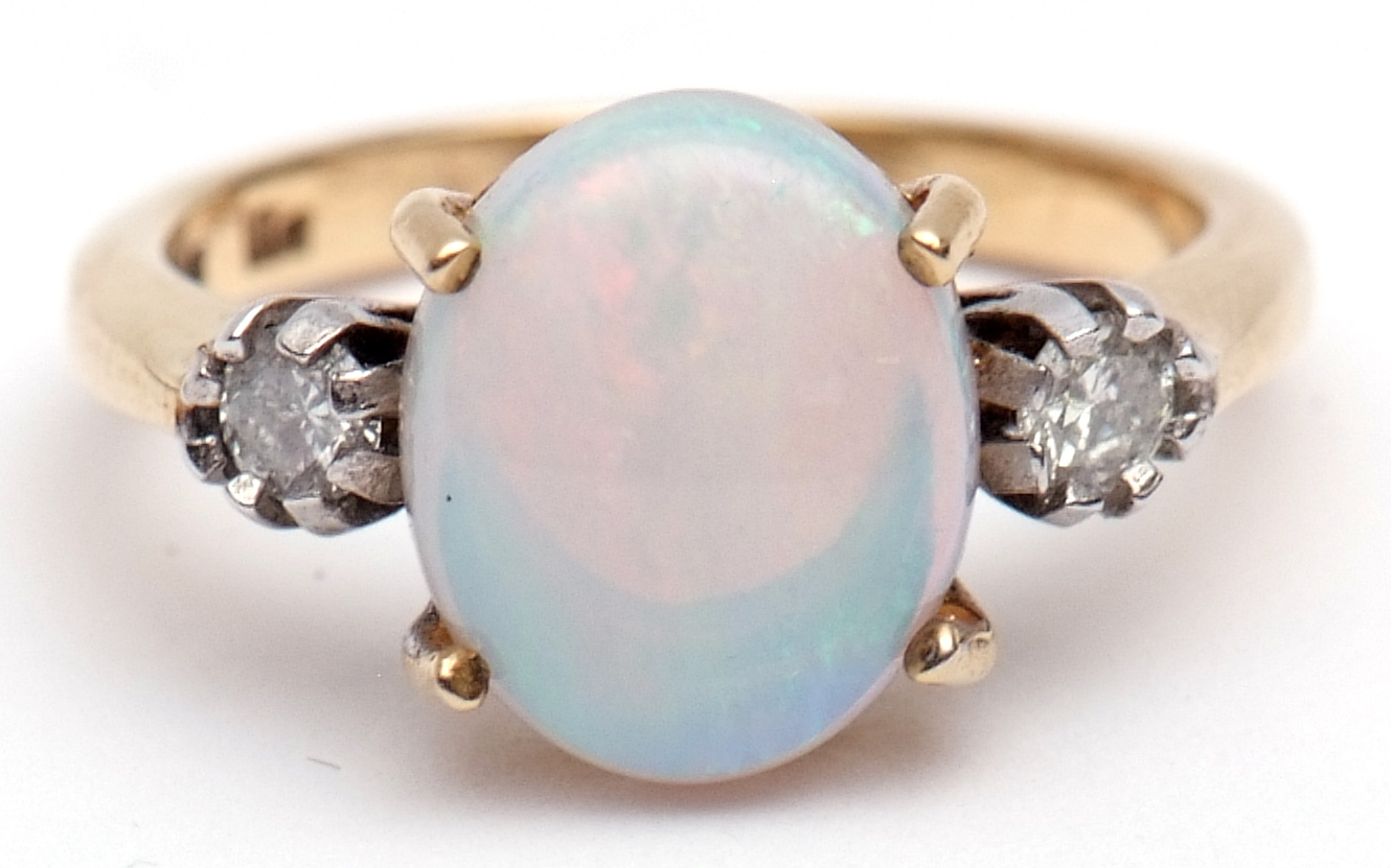 Precious metal opal and diamond ring, the central opal (12 x 8mm) set between two small circular cut