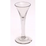 18th century wine glass with plain conical bowl and air drop stem terminating in a spreading
