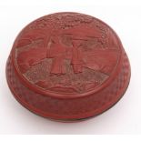 Chinese cinnabar lacquer box of round form, depicting figures in a rocky garden setting, 12.3cm