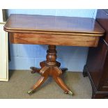 19th century mahogany fold-over tea table with turned column on a quatrefoil base with brass caps