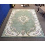 Chinese thick pile wool carpet with a green and cream ground, central floral lozenge and border,