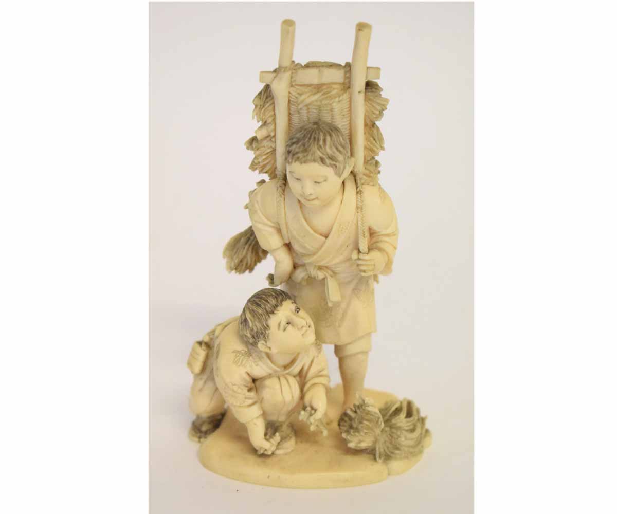 Japanese ivory okimono carved as two young boys gathering brushwood, 14cms high