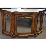 Victorian walnut serpentine front credenza fitted with three mirrored doors with carved scrolling