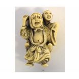 Japanese ivory netsuke modelled as a street performer and his son, signed to foot