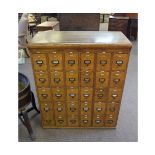Early 20th century oak 30-drawer haberdashery cupboard with decorative cup handles and name plate