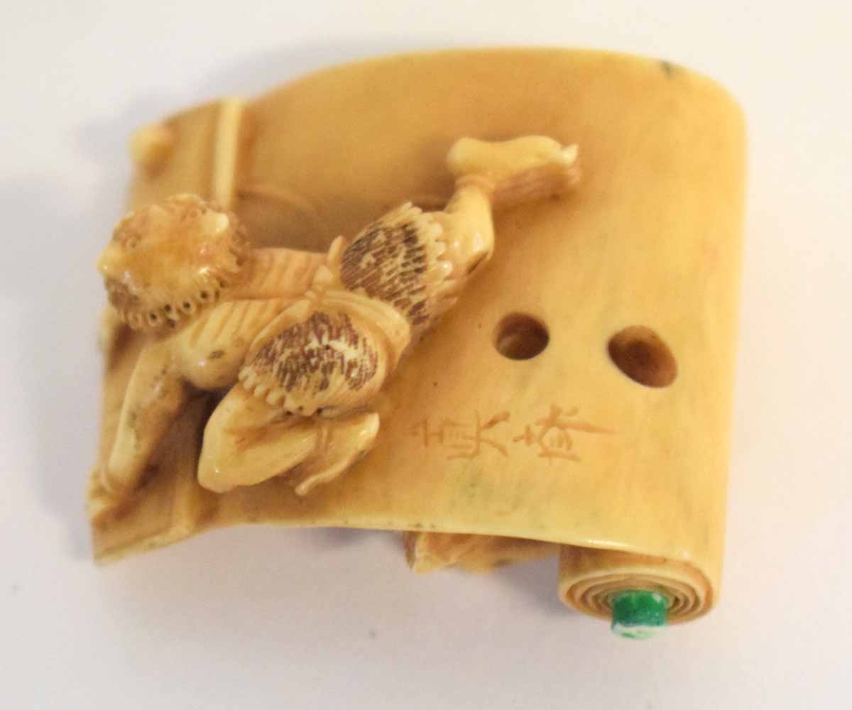 Japanese ivory netsuke carved with Shoki chasing an Oni over a scroll - Image 2 of 2