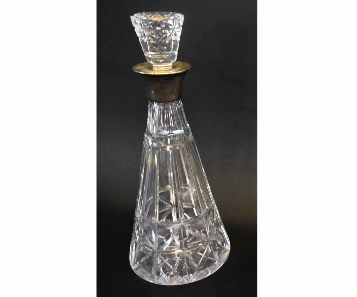 Clear cut glass conical formed decanter with a silver rim and matching stopper (damage to