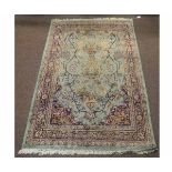 Modern Indian type floor rug with a green ground and central urn and floral border, 93cms wide x