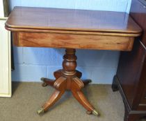 19th century mahogany fold-over tea table with turned column on a quatrefoil base with brass caps