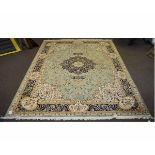 Modern Keshan carpet with a green and cream ground with central blue lozenge, 200cms wide x 280cms