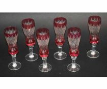 Set of six cut glass and cranberry rimmed small champagne flutes with a twisted stem and a clear