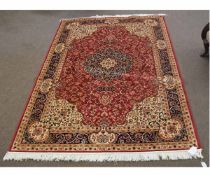 Modern Keshan carpet with a rust and cream ground with floral details and a blue border, 160cms wide