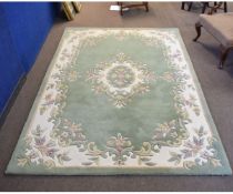 Chinese thick pile wool carpet with a green and cream ground, central floral lozenge and border,