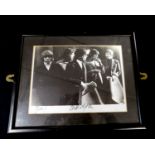 The Rolling Stones, monochrome photograph, signed Bill Wyman + bears signatures of two others (