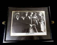 The Rolling Stones, monochrome photograph, signed Bill Wyman + bears signatures of two others (