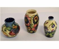 Three modern Moorcroft vases with tube lined designs, the largest 10cms