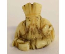 Japanese small carved ivory netsuke of a seated Emperor, 2 1/2cms tall
