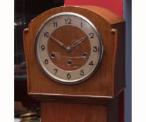 Mid-20th century triple barrel floor standing clock, the arched case with long plain trunk on a