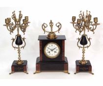 Late 19th century black and rouge marble mounted clock garniture, the plinth shaped case with