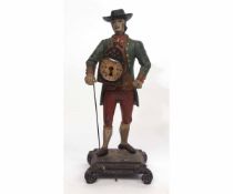 Painted base metal novelty timepiece modelled in the form of a clock seller wearing a green jacket