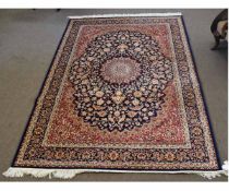 Modern Keshan carpet with a blue and rust field, with central blue lozenge and multi-gulled floral