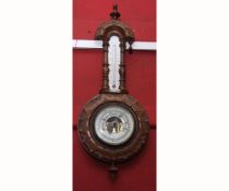 Early 20th century wall mounted aneroid wheel barometer, the shaped case with turned finial and neck