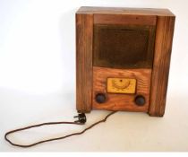 Mid-20th century pine cased valve radio, of rectangular form with cloth covered speaker over two