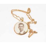 Gold plated pendant and neckchain, the circular pendant glazed both sides and bearing a head and