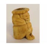 Oriental carved bone netsuke of a seated figure (drilled), 4cms tall