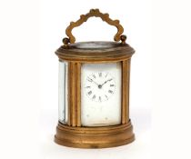 Late 19th century French small oval carriage timepiece, the oval case with shaped carry handle and