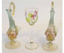 Wine glass with coloured floral design together with two glass ewers, modelled as fish