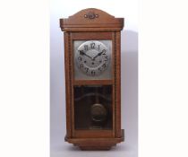 Mid-20th century oak cased triple barrel wall clock, the case with shaped pediment to a panelled and