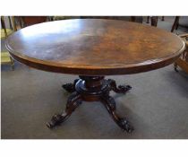 Victorian walnut oval top loo table with a carved column and supported by quatrefoil carved