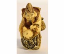 Japanese ivory netsuke of a fisherman holding a fish, signature to his back, 4 1/2cms tall