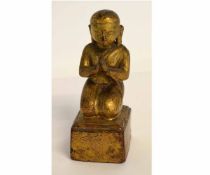 Small carved and gilded wood figure of a praying Buddha, 15cms tall