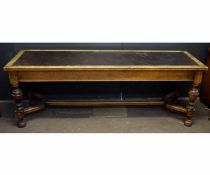 Good quality large brown leather topped table on four turned legs, with a geometric H stretcher,