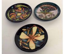 Three modern Moorcroft pin trays, with tube lined designs, all 12cms diam